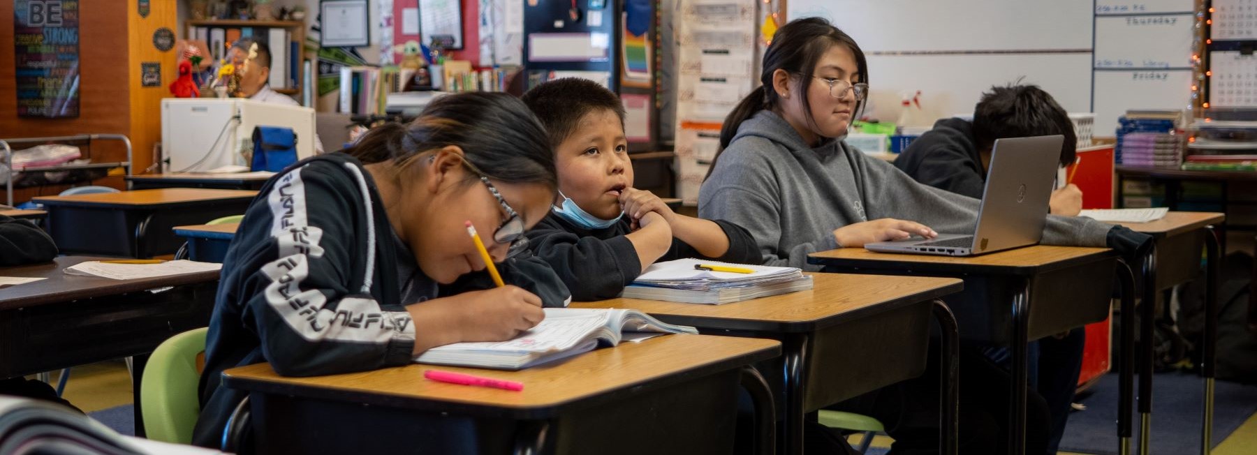 Group of students focused on their work in a classroom at Tohaali Community School.